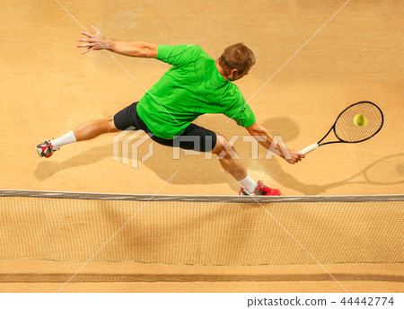 The one jumping player, caucasian fit man, playing tennis on the earthen court 44442774