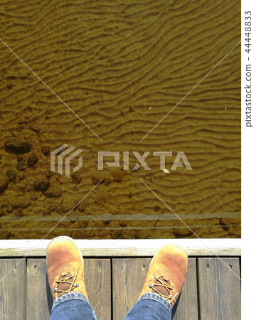 feet in suede shoes on a dock 44448833