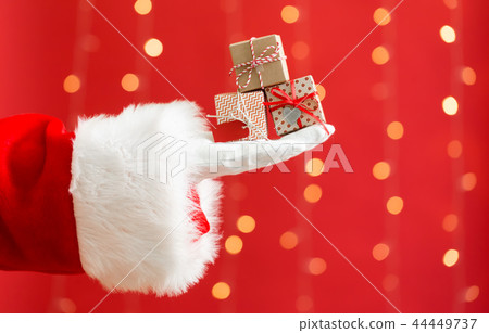 Santa holding small Christmas gift boxes 44449737