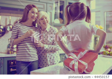 Delighted mom and granny staring at their kid 44450157