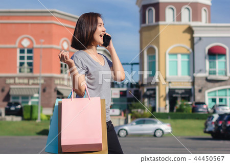 Asian woman using smartphone while buy cosmetics. 44450567
