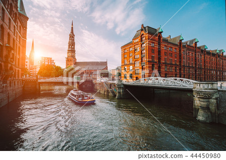 Touristic cruise boat on a channel with bridges in the old warehouse district Speicherstadt in 44450980