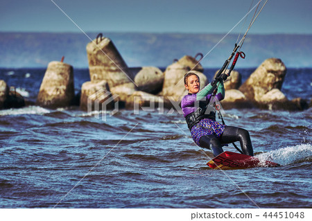 A female kiter slides on the surface of the water A female kiter slides on the surface of the water 44451048
