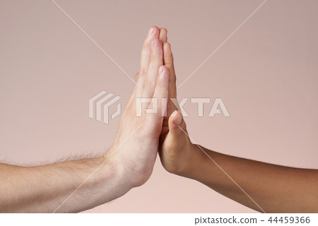 Caucasian give high five to dark skin person 44459366