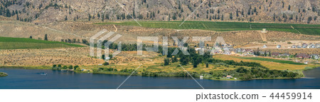 Okanagan valley panoramic view with residential area and orchard farm fields. Residential homes in Okanagan valley panoramic view with residential area and orchard farm fields. Residential homes in 44459914