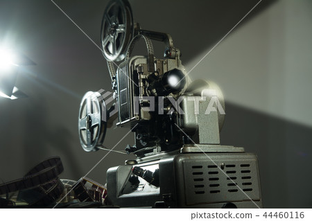 Cinema projector with a film on dark background 44460116