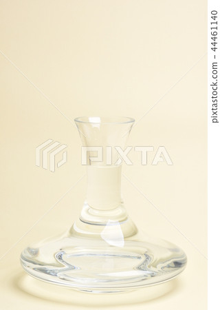 Glass carafe with water on beige background Glass carafe with water on beige background 44461140