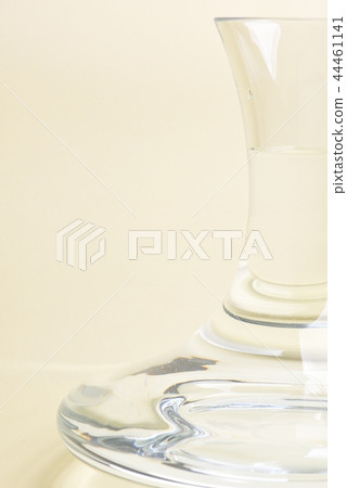 Glass carafe with water on beige background 44461141