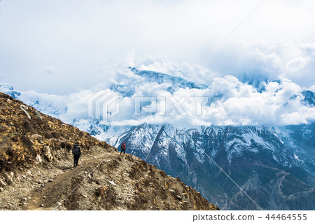 Two tourists walk along the rocky mountain path  44464555