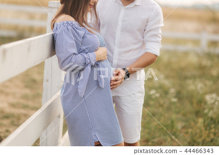 Happy family is waiting for baby. Pregnant woman and her husband in nature Happy family is waiting for baby. Pregnant woman and her husband in nature 44466343