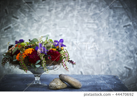 Flower arrangement of pokeweed and marigold in a glass plate Flower arrangement of pokeweed and marigold in a glass plate 44470692