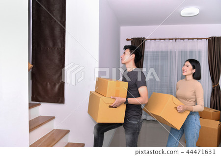 Moving house Concept. Asian young man is carrying his belongings 44471631