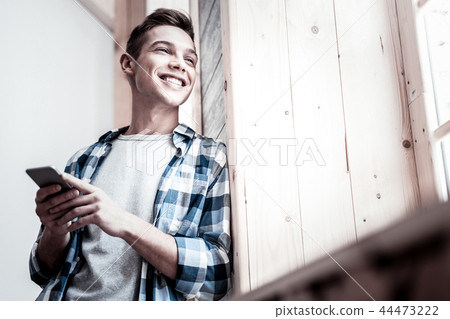 Happy student smiling and looking out of the window 44473222