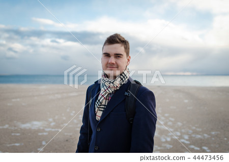 Young beautiful man in elegant clothes on the winter beach in NYC 44473456