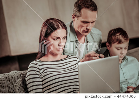 Concentrated brunette female working at her laptop Concentrated brunette female working at her laptop 44474306
