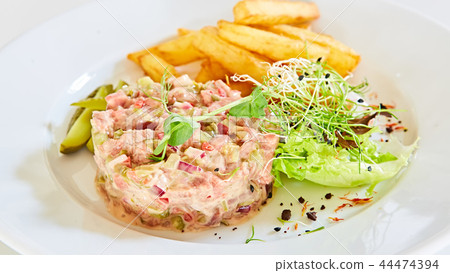 Meat tartar with french fries and vegetable salad. Meat tartar with french fries and vegetable salad. 44474394