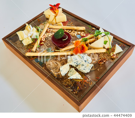 Cheese selection on wooden rustic board. Cheese platter with different cheeses on wood. Cheese selection on wooden rustic board. Cheese platter with different cheeses on wood. 44474409