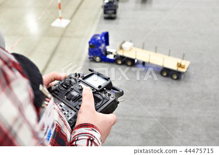 Man with radio remote control and truck model 44475715