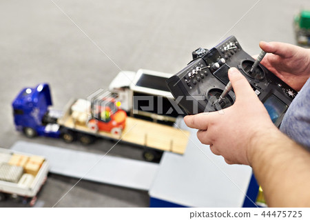 Man with radio remote control and truck model 44475725