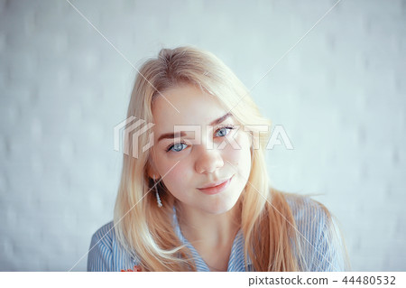 cute blond young adult / portrait of an adult beautiful girl model with blond hair in a happy image 44480532