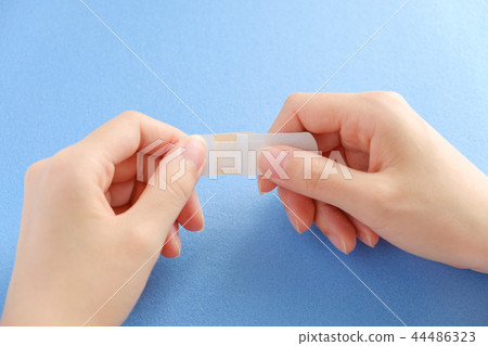 Hand holding a bandage Hand holding a bandage 44486323