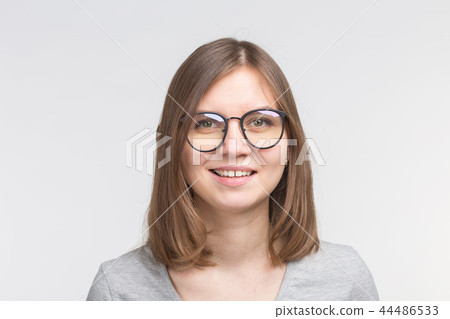 Portrait of laughing happy brown hair woman in a glasses over white background Portrait of laughing happy brown hair woman in a glasses over white background 44486533
