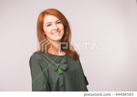Fashion and people concept - Portrait of happy ginger woman smiling over white background with copy Fashion and people concept - Portrait of happy ginger woman smiling over white background with copy 44486565