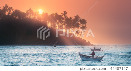 Tropical beach on sunset with fishermen and sea Tropical beach on sunset with fishermen and sea 44487147