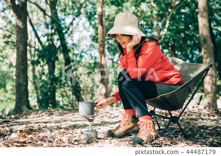 Woman cooking in the mountains Woman cooking in the mountains 44487179