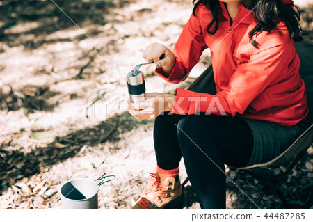 Woman sowing beans in a coffee mill Woman sowing beans in a coffee mill 44487285