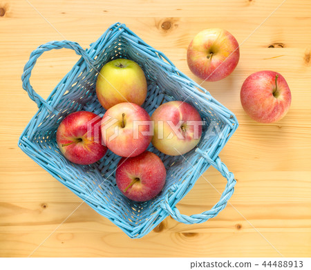 Red apples in blue wooden basket Red apples in blue wooden basket 44488913