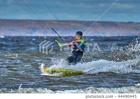 A male kiter slides on the surface of the water. 44490445