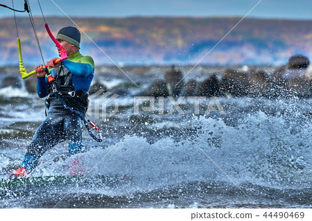 A male kiter slides on the surface of the water. 44490469