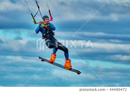 A male kiter jumps over a large lake. Close-up. A male kiter jumps over a large lake. Close-up. 44490472