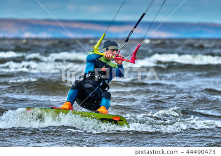 A male kiter slides on the surface of the water. A male kiter slides on the surface of the water. 44490473