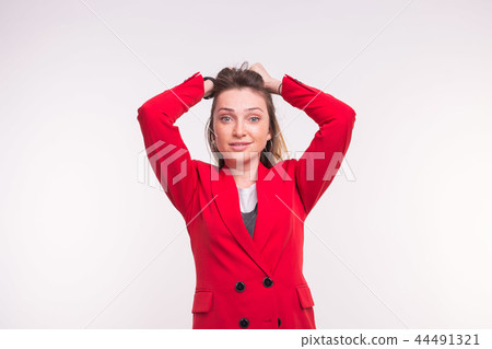 Surprised freckled young woman wearing red suit on white background 44491321
