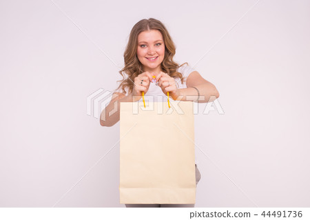 People, sale and consumerism concept - Beautiful woman over white background holding shopping bags 44491736