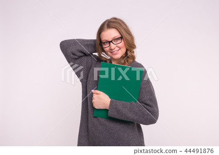 Beautiful student young woman in glasses holding green paper folder on white background Beautiful student young woman in glasses holding green paper folder on white background 44491876