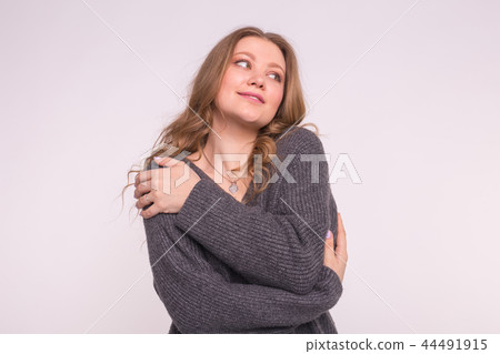Close up portrait of caucasian tender woman with curly hair wearing gray cardigan on white 44491915
