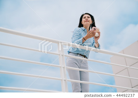 an elegant woman standing outdoor with a blue sky an elegant woman standing outdoor with a blue sky 44492237