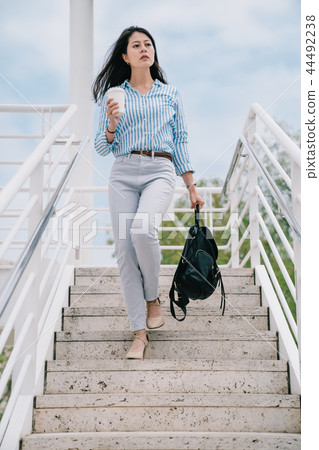 female traveler walking down the stairs female traveler walking down the stairs 44492238