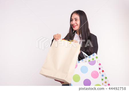 Happy asian woman with red lips holding shopping bags on white background with copy space 44492758