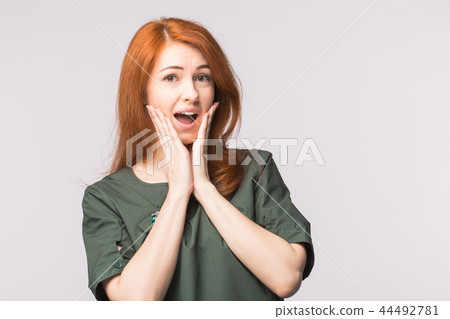 Surprised redhead young woman on white background 44492781