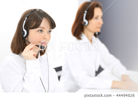 Call center. Group of operators at work. Focus on young brunette woman. Business concept Call center. Group of operators at work. Focus on young brunette woman. Business concept 44494826