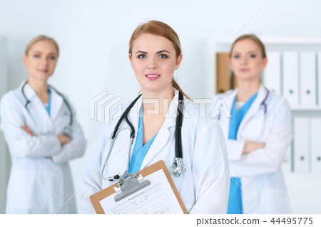 Group of medical doctors standing at hospital. Team of physicians ready to help patients. Medicine Group of medical doctors standing at hospital. Team of physicians ready to help patients. Medicine 44495775