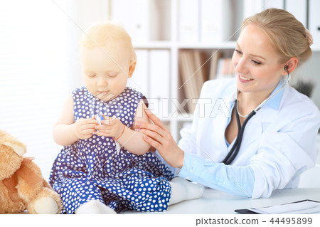 Doctor and patient in hospital. Little girl is being examined by pediatrician with stethoscope Doctor and patient in hospital. Little girl is being examined by pediatrician with stethoscope 44495899