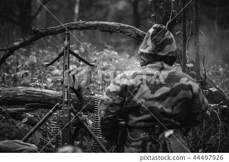 Hidden German Wehrmacht Soldier Sitting With Machine Gun In An A Hidden German Wehrmacht Soldier Sitting With Machine Gun In An A 44497926