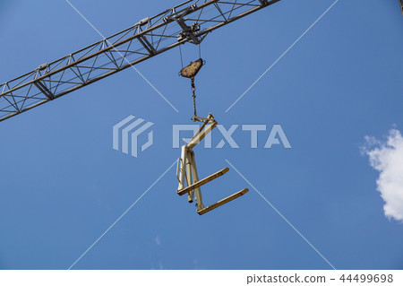 Crane lifting Pallet .Blue sky on background Crane lifting Pallet .Blue sky on background 44499698