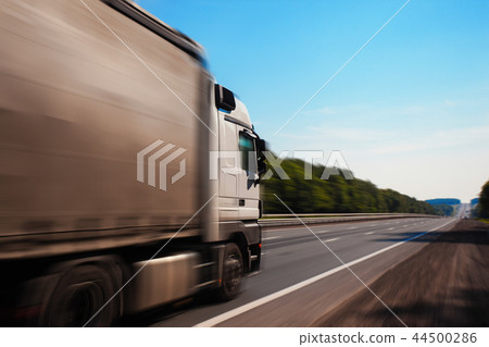 a truck is driving down the road 44500286