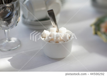 a white cup of sugar cubes raffinate a white cup of sugar cubes raffinate 44500292